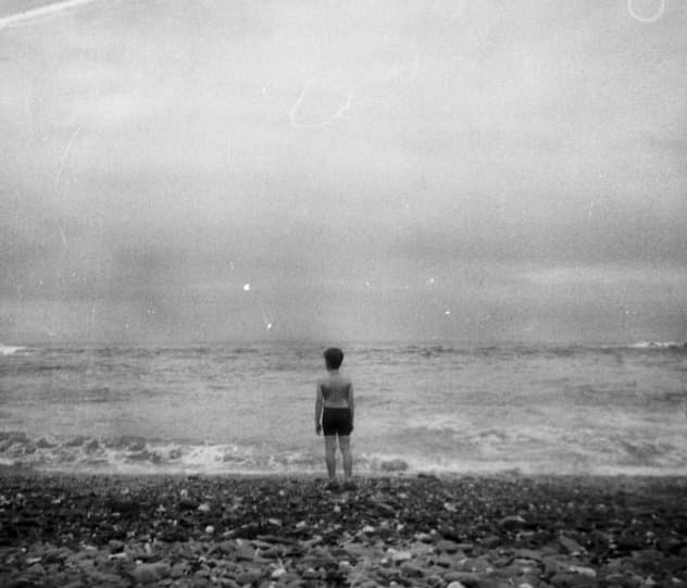 Old black and white photo of young self on beach