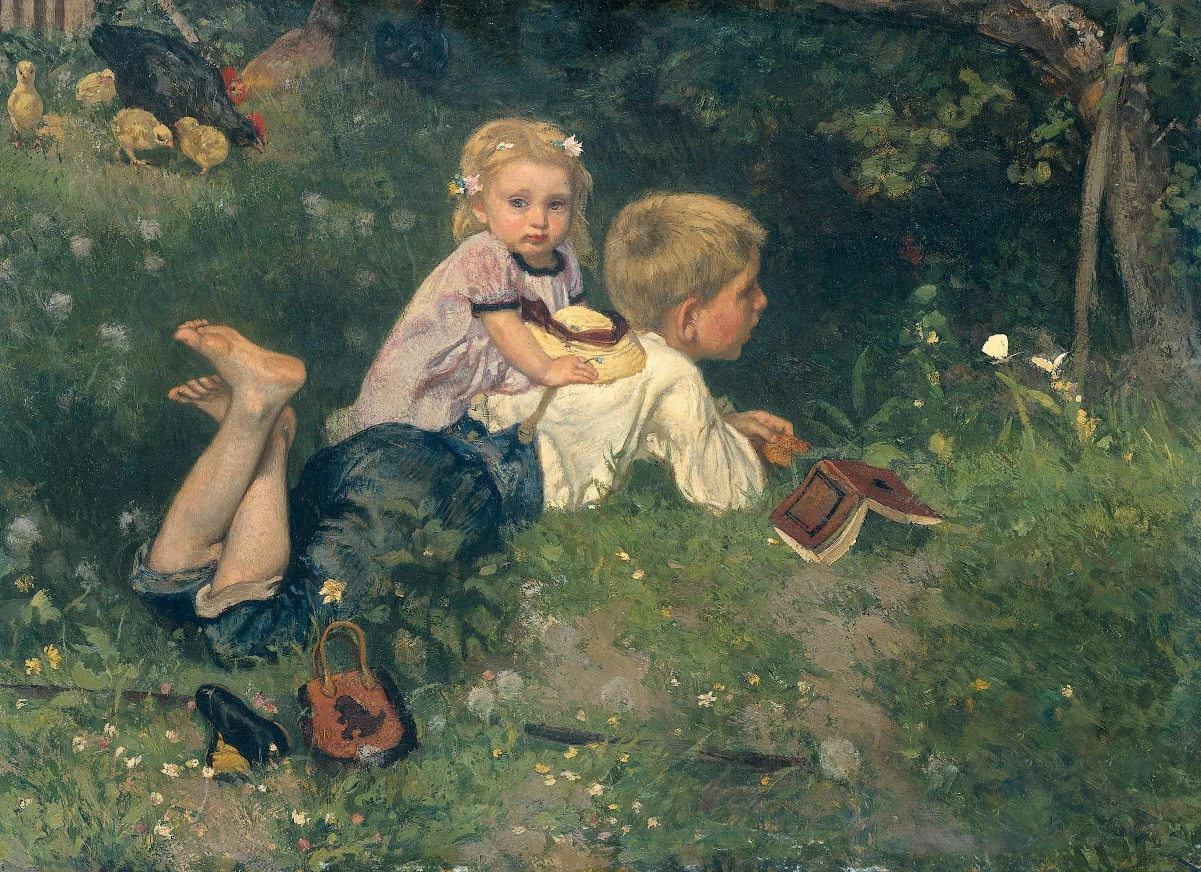 Two young children reading in grass